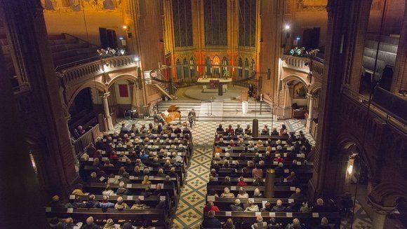 Foto von der Orgelempore auf die gefüllten Bankreihen in der Apostel-Paulus-Kirche während einer Veranstaltung