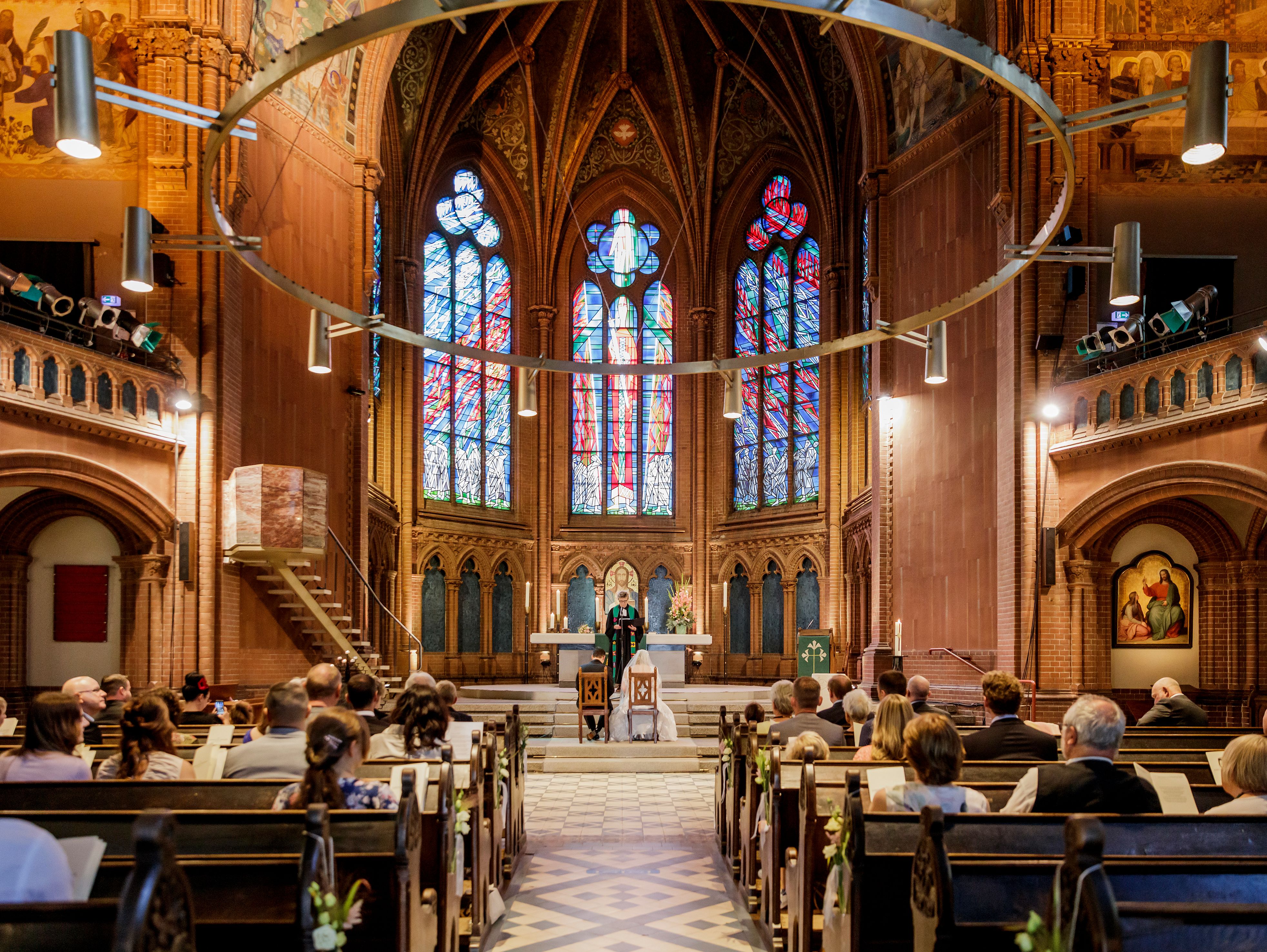 Brautpaar und Pfarrerin Steffen-Elis im Altarraum der Apostel-Paulus-Kirche
